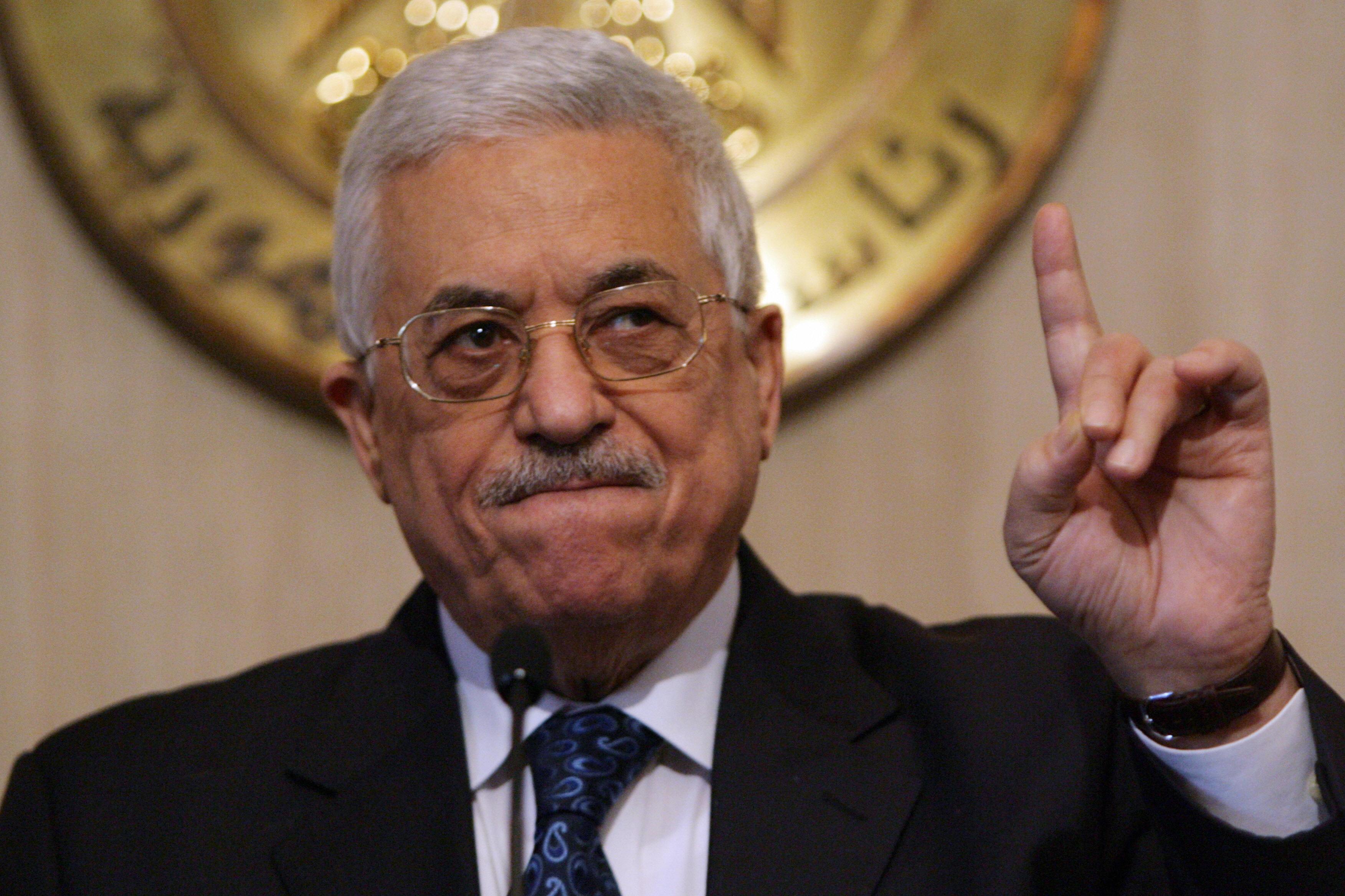Palestinian leader Mahmoud Abbas holds a