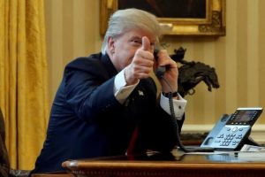 U.S. President Donald Trump gives a thumbs-up to reporters as he waits to speak by phone with the Saudi Arabia's King Salman in the Oval Office at the White House in Washington